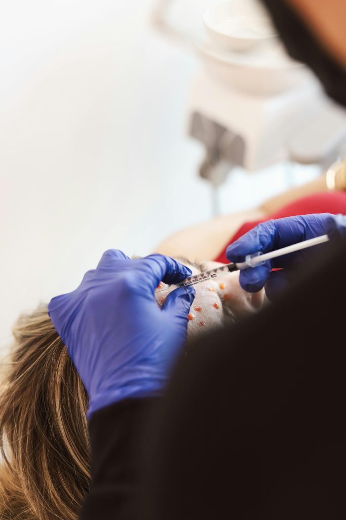 pexels-photo-27925593-27925593 A medical professional performs a facial injection on a patient in a clinic setting.