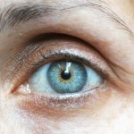 Detailed close-up image of a woman's blue eye revealing intricate details.